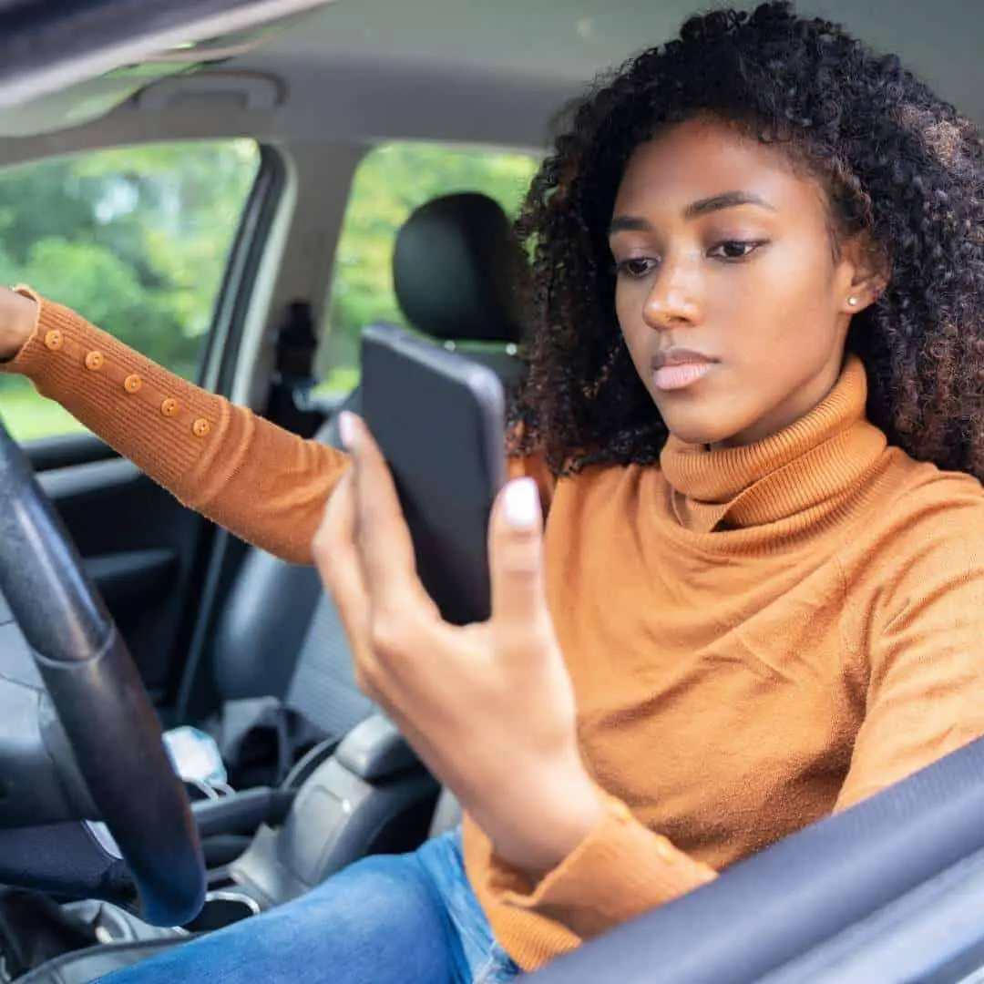 women_using_phone_while_driving.jpeg